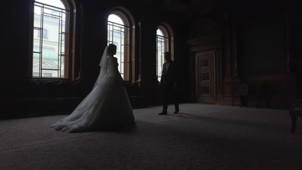 Bride and groom are going to meet each other in a luxurious interiors with big windows
