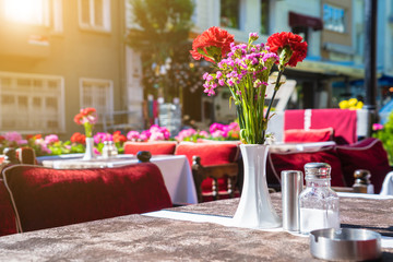 Fototapeta na wymiar Outdoor summer cafe tables with beautiful flower,europe restaura