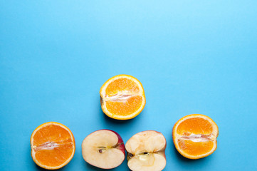 Fototapeta na wymiar Oranges and apples on blue background