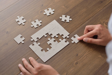 Folding puzzle hand parts on a wooden table