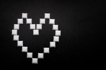White heart made from white bricks over black textured background