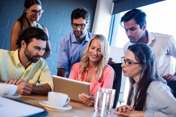Group of coworkers watching a tablet computer
