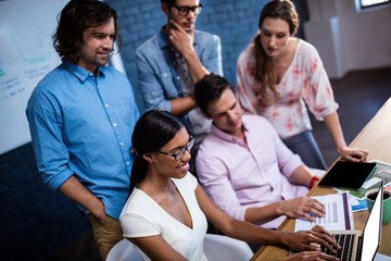 Group of coworkers watching a laptop