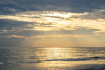 Yellow warm sun light  with dark clouds at the sea