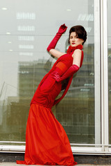 Beautiful woman in red dress on the background of a large window