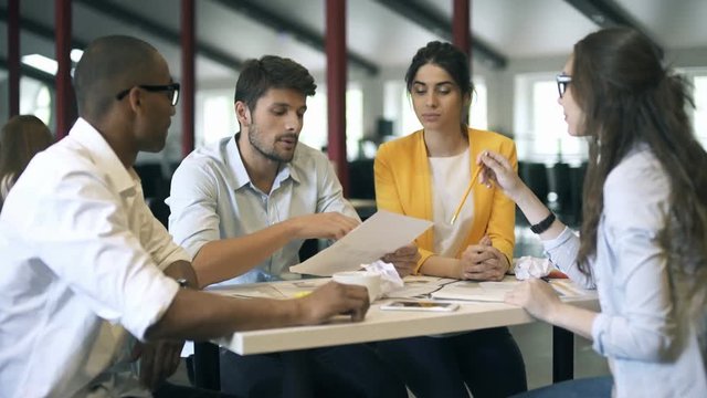 Young business partners discussing ideas or project at meeting in office