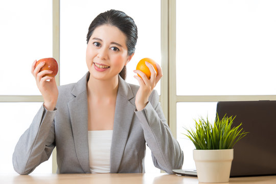 Young asian businesswoman eating healthy snack - Powered by Adobe