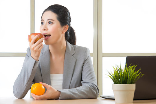 Young asian businesswoman eating healthy snack - Powered by Adobe