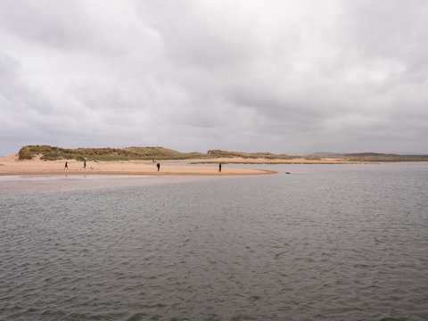 Visitors enjoying a walk along the beach at Lossiemouth, Morray Firth, Scotland, UK,
