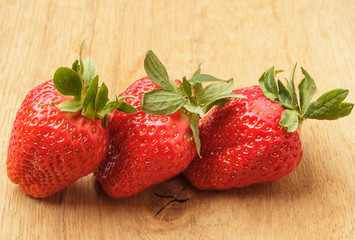Red fresh strawberry fruits on wooden table.