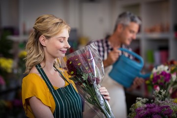 Happy female florist smelling a flower bouquet