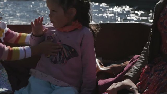 Two little girls with their parents in a tourist boat along the rivers