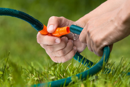 hands connecting hoses for irrigation in the garden