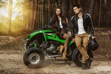 Fototapeta na wymiar Couple and ATV in the forest