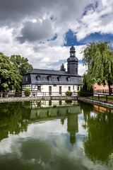 Fototapeta na wymiar Bucha, Thuringia, Germany: Village church with green, pond and trees