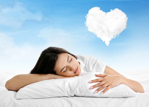 Beautiful girl lying on blue cloudy sky and dreaming about love