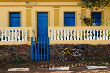 portão azul e bicicleta estacionada em frente a uma casa típica do interior de São Paulo