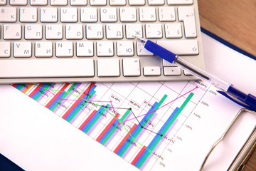 Office table with blank notepad and laptop