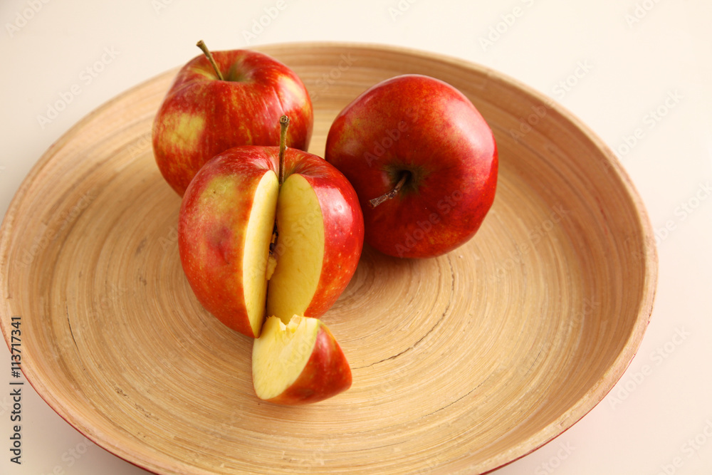 Wall mural Red apples on a wooden plate on the table