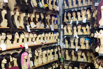 Mannequins with variegated style wigs on shelves