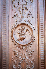 Angel engraved on the wooden portal of an ancient church.