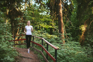 Naklejka na ściany i meble Girl runs along the forest trail