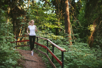 Naklejka na ściany i meble Girl runs along the forest trail