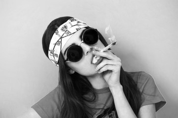 Hippy girl portrait smoking weed and wearing sunglasses