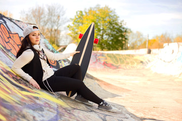 young woman at a skatepark with her board