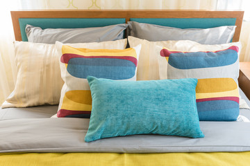 Fototapeta na wymiar colorful pillows on wooden bed in modern bedroom