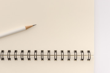 white pencil with blank notebook on white