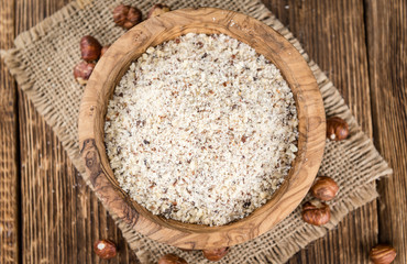 Wooden table with grounded Hazelnuts