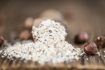 Wooden table with grounded Hazelnuts