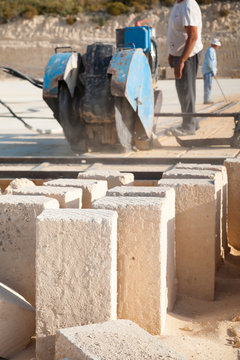 Just cut tufa blocks while workers are using a sawing machine to cut the stone vertically