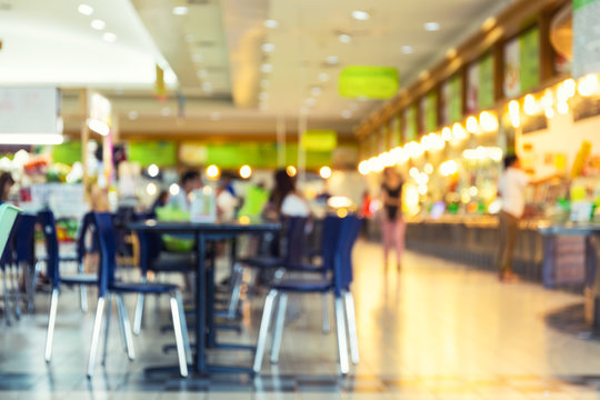 Food court or food center in shopping mall. Interior consist of table, restaurant, coffee shop. Busy with  people to buy food and eating. Similar of canteen for shopping mall. Blurred background.