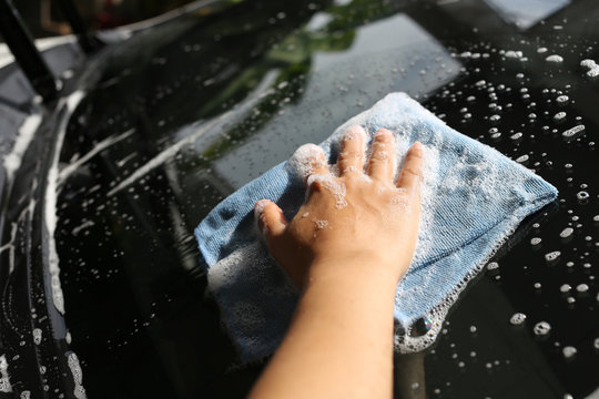 Women Hand in Wash a car with Microfiber Cloth.