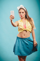 Fototapeta na wymiar Retro girl with smartphone taking selfie