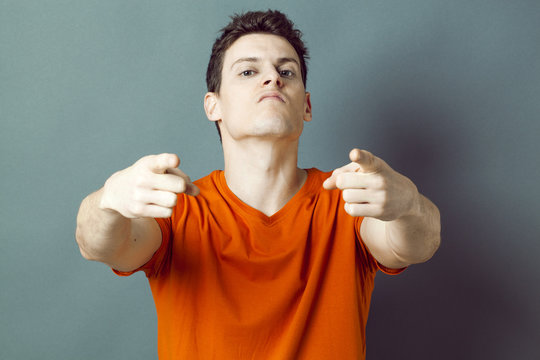 arrogant young man targeting the foreground for aggressive attitude