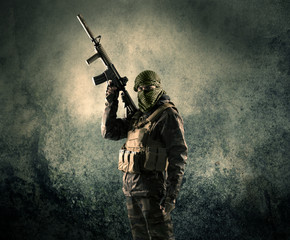 Portrait of a heavily armed masked soldier with grungy backgroun