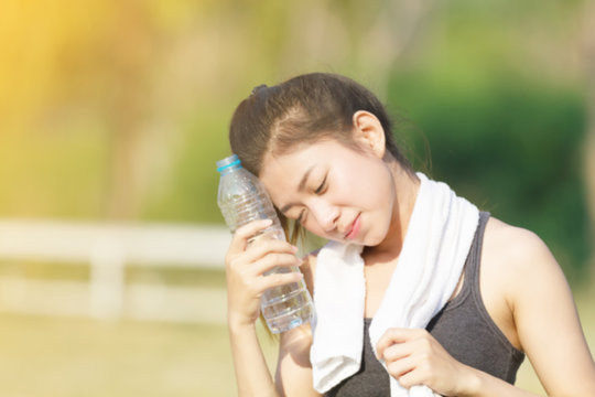 Sporty woman asia drinking water outdoor on sunny day