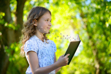 Little girl reading a book and flying letters