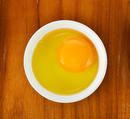 Egg yolk in the bowl on wooden background