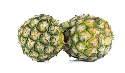 two green pineapples on white bacground