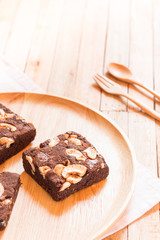 Chocolate brownie cake served on wooden plate.Selective focus on flork.
