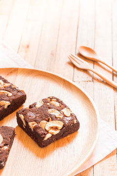 Chocolate brownie cake served on wooden plate.Selective focus on flork.