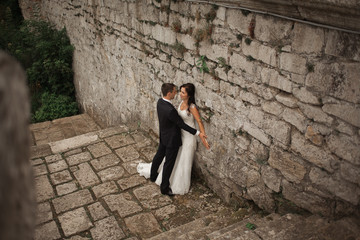 Beautiful romantic wedding couple of newlyweds hugging near old castle 