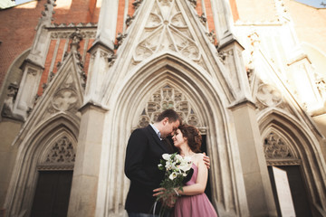 Obraz premium Elegant beautiful wedding couple posing near a church. Krakow