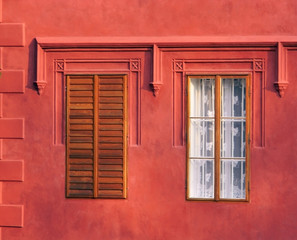 color detail photography of two windows in red wall of historical building