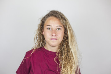 Close up portrait of smiling pretty teenager with curly hair and