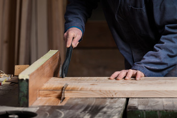 Carpenter's hands cutting wood board with Table Saw